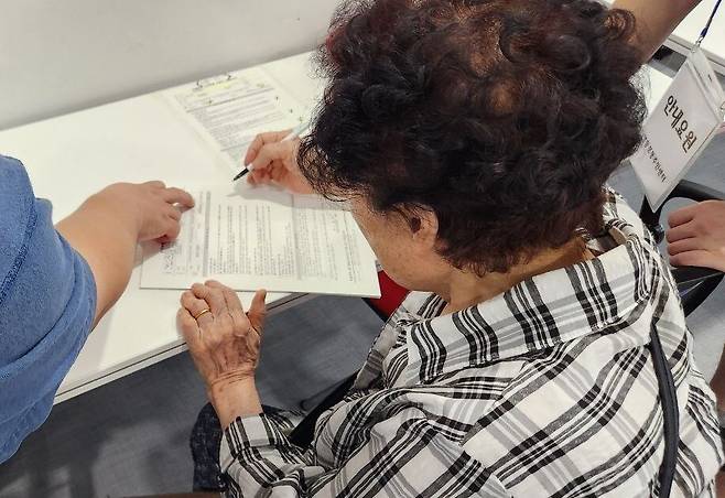 21일 오후 서울 영등포구 영등포동 주민센터에서 민생회복 소비쿠폰 신청서를 작성하는 모습. 장종우 기자