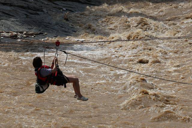 20일 경기 가평군 마일리의 한 캠핑장에 고립된 시민들이 소방 로프를 타고 탈출하고 있다. 뉴스1