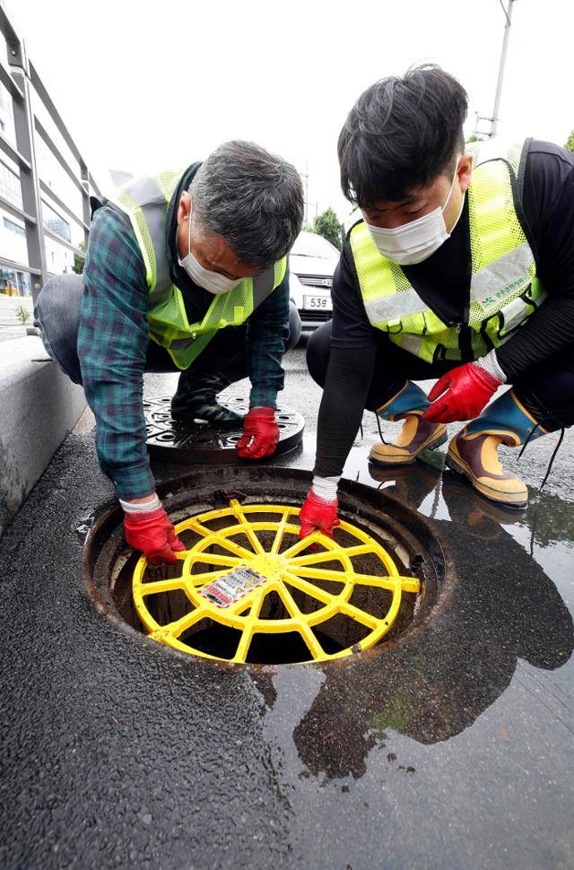 광주 북구청 직원들이 지난 2023년 장마철 집중호우에 대비해 설치한 맨홀 추락방지시설을 점검하고 있다. 광주=뉴시스