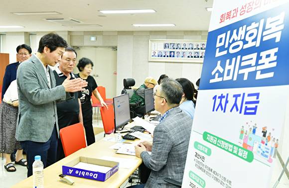 조현일 경산시장(왼쪽)이 민생회복소비 쿠폰 지급 현장을 찾아 직원들을 격려하고 있다 [사진=경산시]