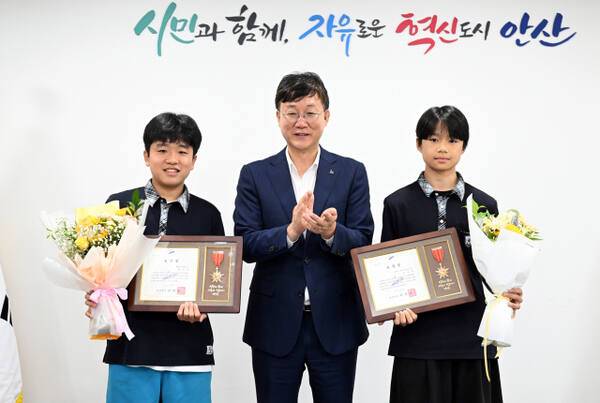 무더위 속 폐지를 싫은 무거운 수레를 끌고 거리를 지나던 어르신을 도운 중학교 재학생 2명 안산시장으로 선행 표창장을 받았다(사진의 왼쪽이 양시온·오른쪽은 유호현 학생). 안산시 제공