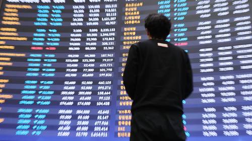 서울 여의도 한국거래소 홍보관에서 한 시민이 전광판 앞을 지나는 모습. [사진 출처 = 연합뉴스]