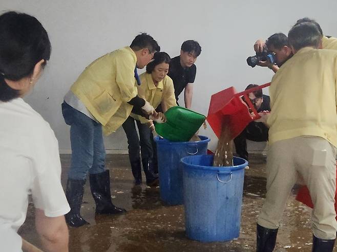 더불어민주당 당대표 선거에 출마한 박찬대 후보가 21일 광주 서구의 한 가구점 지하에서&nbsp;쓰레받기로 물을 퍼내며 수해 복구 작업을 하고&nbsp;있다. 조희연 기자