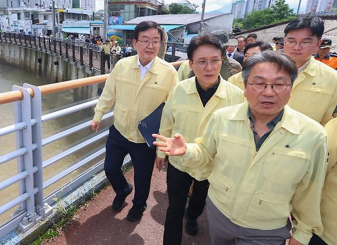 김민석 국무총리가 20일 오전, 광주시 북구 신안교를 찾아 강기정 광주시장으로부터 제방 유실 및 침수 피해 현황 보고를 받은 뒤 현장을 둘러보고 있다. 서류철을 겨드랑이에 낀 왼쪽 첫 번째가 문인 광주북구청장 ⓒ연합뉴스