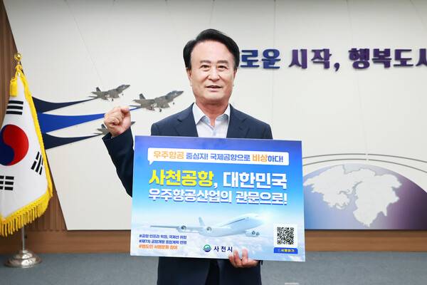 박동식 사천시장이 22일 사천공항의 국제공항 승격을 위한 홍보 피켓을 들고 있다. /사천시