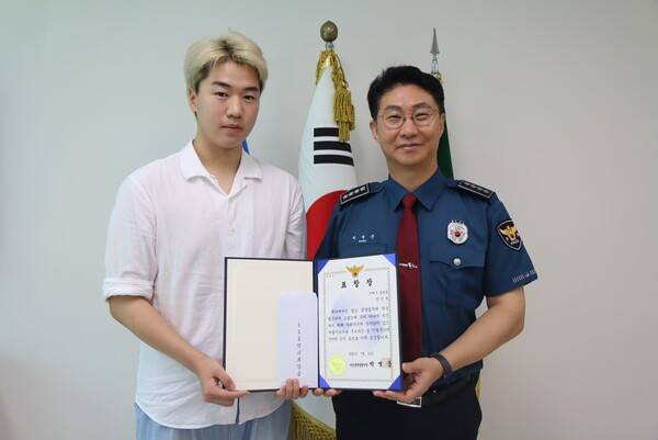 강민성(왼쪽) 씨가 22일 창원 마산합포구 마산중부경찰서 청사에서 박병준(오른쪽) 마산중부경찰서장에게 표창장을 전달받고 기념사진을 찍고 있다. /마산중부경찰서