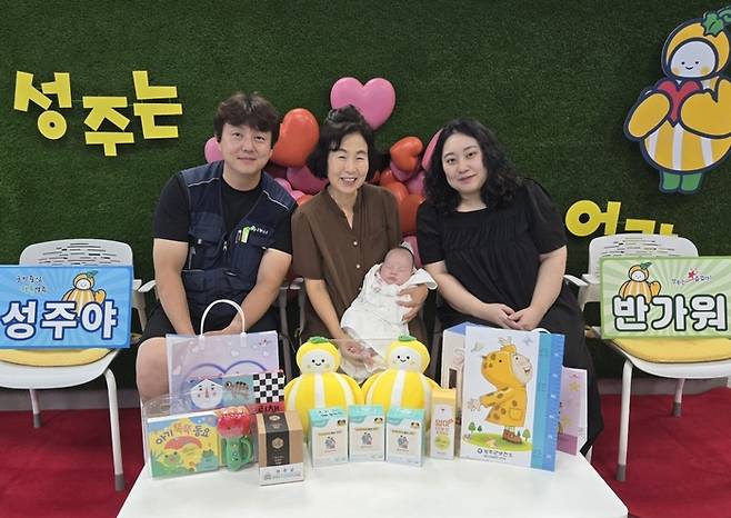 성주군의 찾아가는 산부인과 사업을 통해 1천번째 태어난 김성주군의 가족에게 22일 출산축하선물을 전달하고 기념사진을 촬영하고 있다. <성주군 제공>