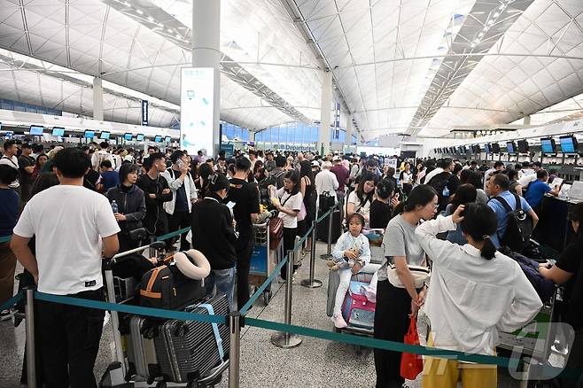 20일 태풍 위파가 홍콩을 지나는 동안 홍콩 국제공항에서 출국 승객들이 탑승 수속을 위해 길게 줄을 서고 있다. 홍콩공항관리국에 따르면, 기상 악화로 인해 약 500편의 항공편이 취소됐으며, 이후 당일 중 약 400편의 항공기가 이륙하거나 착륙할 예정이다.2025.07.20.ⓒ AFP=뉴스1