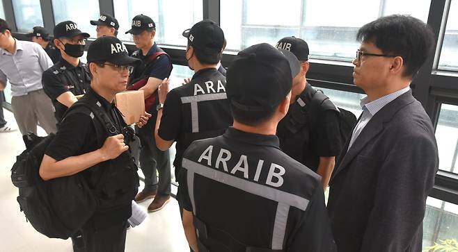항공·철도사고 조사위원회(ARAIB) 관계자들이 지난 19일 오후 전남 무안국제공항에서 열린 '12.29 여객기 참사 엔진 정밀조사 결과 현장 브리핑'에 참석하던 중 유가족들의 항의로 인해 회의실 입장을 대기하고 있다./뉴스1