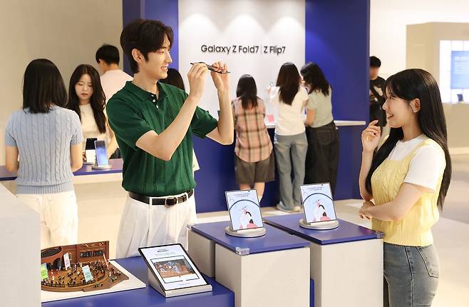더현대 서울에 오픈한 '갤럭시 스튜디오'에서 방문객들이 '갤럭시 Z 폴드7'의 초슬림 두께를 체험하는 모습. /삼성전자
