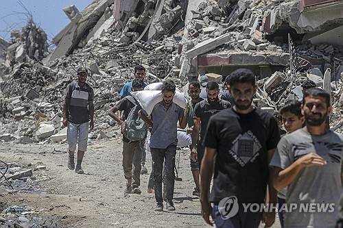 구호품 받아 이동하는 가자지구 주민들. EPA 연합뉴스 자료사진