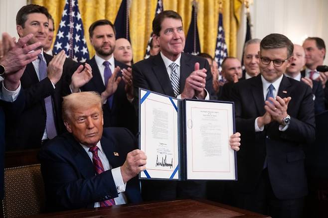 도널드 트럼프(왼쪽) 미국 대통령이 18일(현지시간) 워싱턴 백악관에서 공화당 의원들이 참석한 가운데 암호화폐 규제법인 이른바 지니어스법 서명식을 하고 있다. UPI 연합