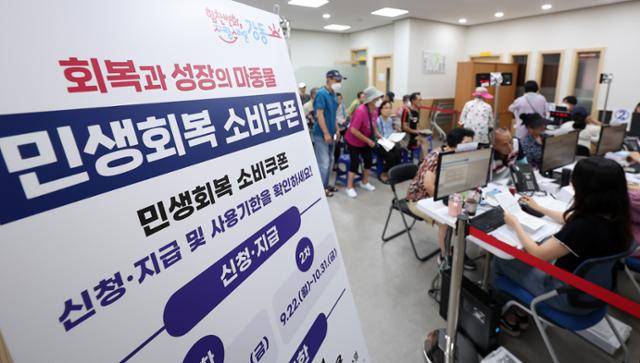 민생회복 소비쿠폰 1차 신청 둘째 날인 22일 서울 강동구 암사 1동 주민센터를 찾은 시민들이 소비쿠폰을 신청하고 있다. 뉴스1