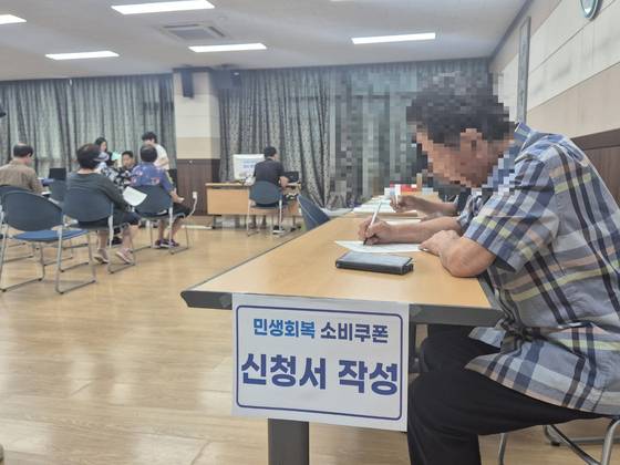 충북 청주시 성안동 행정복지센터를 찾은 한 주민이 소비쿠폰 발급을 위해 신청서를 작성하고 있다. 최종권 기자