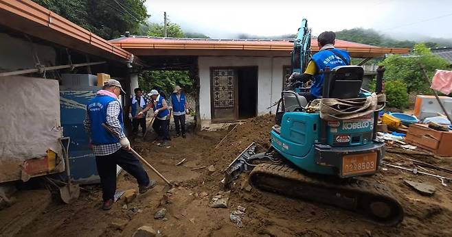 산불 피해를 본 경북 영양군 주민들이 22일 수해 피해를 본 경남 산청군을 찾아 굴삭기로 토사 정리하고 있다. 영양군 제공