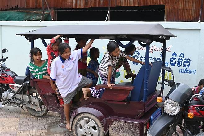 프놈펜 스텅미언체이 빈만가 아이들이 21일 프놈펜 영문 마당의 툭툭을 놀이기구 삼아 장난을 치고 있다.