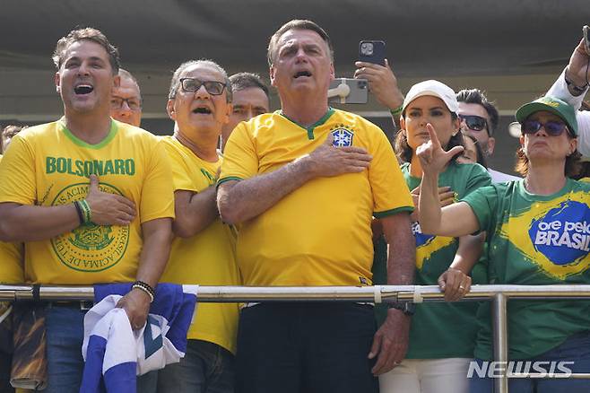 [상파울루=AP/뉴시스] '브라질의 트럼프' 자이르 보우소나루 전 브라질 대통령이 25일(현지시각) 상파울루에서 열린 집회에 참석해 국민의례를 하고 있다. 쿠데타 모의 의혹과 귀금속 불법 반입 등의 혐의로 검찰 조사를 받고 있는 보우소나루 전 대통령은 '법과 자유 수호를 위한 집회'라는 이름으로 대규모 집회를 열고 세를 과시하고 있다. 2024.02.26.