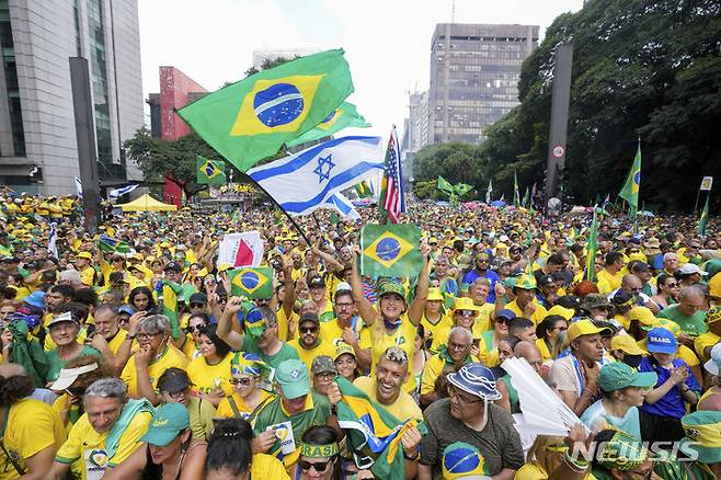 [상파울루=AP/뉴시스] 자이르 보우소나루 전 브라질 대통령 지지자들이 25일(현지시각) 상파울루에서 열린 집회에 참석해 환호하고 있다. 쿠데타 모의 의혹과 귀금속 불법 반입 등의 혐의로 검찰 조사를 받고 있는 보우소나루 전 대통령은 '법과 자유 수호를 위한 집회'라는 이름으로 대규모 집회를 열고 세를 과시하고 있다. 2024.02.26.