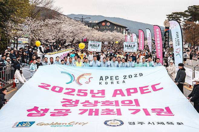 2025 APEC 정상회의 성공 개최를 기원하며 열린 경주 벚꽃마라톤대회 참가자들이 대형 현수막을 펼치고 응원의 메시지를 전하고 있다. 경주시 제공