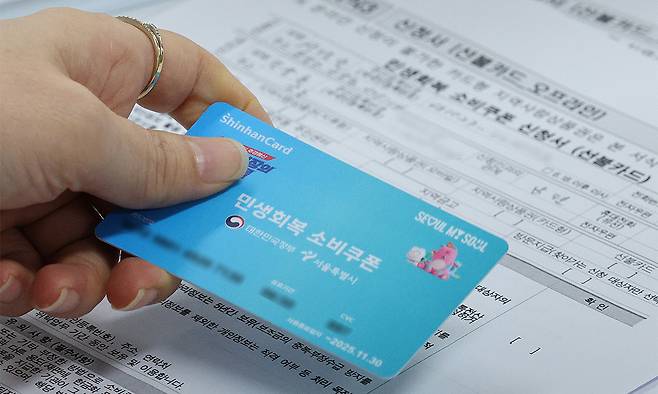 민생회복 소비쿠폰 1차 신청 첫 날인 21일 서울 동작구 사당1동주민센터를 찾은 시민들이 민생회복 소비쿠폰을 신청하고 있다. 뉴스1