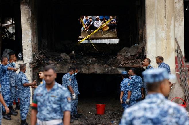 방글라데시 다카의 마일스톤 스쿨 앤드 칼리지 캠퍼스에 공군 훈련기가 추락한 사고 이튿날인 22일(현지시간) 공군과 수사기관 관계자들이 사고 현장을 조사하고 있다. 2025.7.22 로이터 연합뉴스