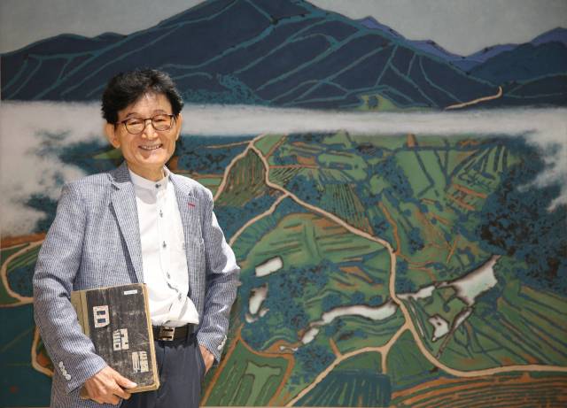 임무상 화백이 고등학교 1학년 때인 1959년 일기장을 들고 문경 돌리네습지 탐방센터에 걸린 자신의 그림