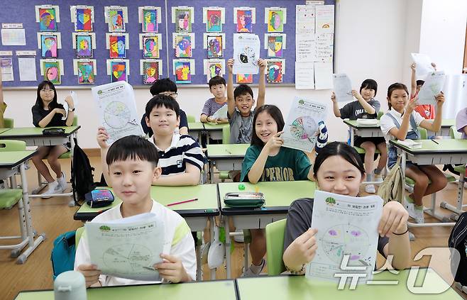 23일 서울 동작구 삼일초등학교에서 열린 여름 방학식에서 학생들이 여름방학 계획표를 들어보이며 기뻐하고 있다. 2025.7.23/뉴스1 ⓒ News1 박지혜 기자