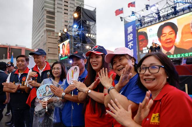 21일 대만 타오위안시에서 열린 국민소환 반대 집회에 참여한 시민들이 팔로 X자를 들어 보이며 투표 당일에 반대표를 던져달라는 의미의 제스처를 하고 있다./ 로이터 연합뉴스