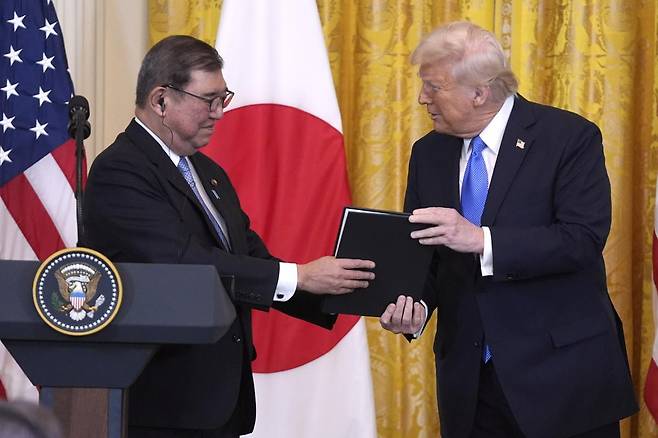 도널드 트럼프 대통령(오른쪽)이 워싱턴 백악관에서 열린 기자회견에서 이시바 시게루 일본 총리에게 사진을 선물하고 있다.  2025.07.23 [AP /뉴시스]