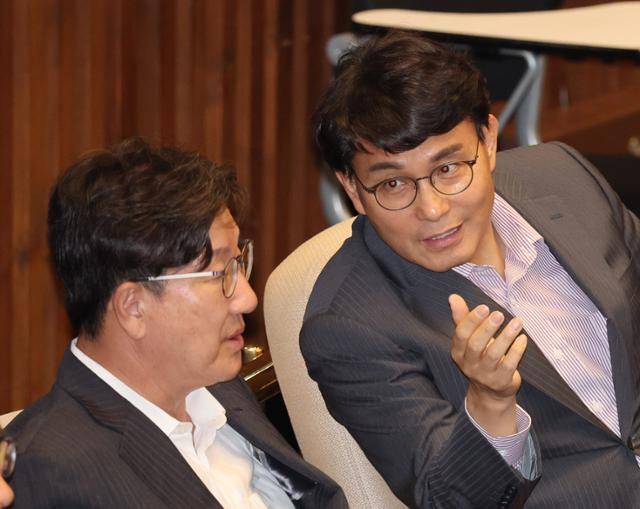 윤상현(오른쪽) 국민의힘 의원이 23일 서울 여의도 국회에서 열린 본회의에서 권성동 국민의힘 의원과 대화하고 있다. 뉴시스