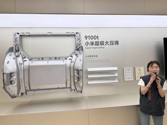 16일 찾아간 샤오미 전기차 수퍼팩토리 전시실에서 안내 직원이 샤오미가 자체 개발한 알루미늄 신소재인 샤오미 타이탄 메탈과 주물 기계인 다이캐스팅 T9100의 성능을 설명하고 있다. 신경진 기자
