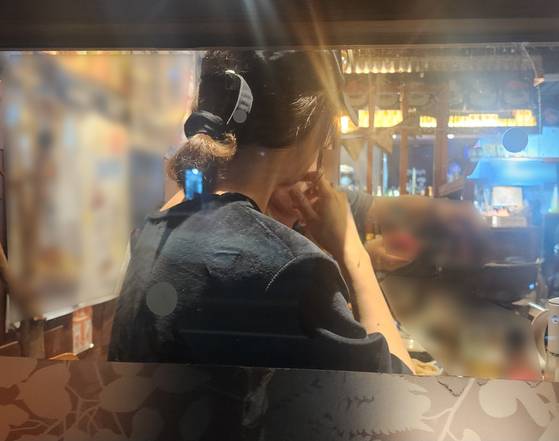 숨진 A양의 어머니 H씨가 6월 25일 밤 부산 해운대구의 한 식당에서 취재팀을 만나 이야기를 나누고 있는 장면. 창 바깥에서 찍은 모습이다. 박성훈 기자