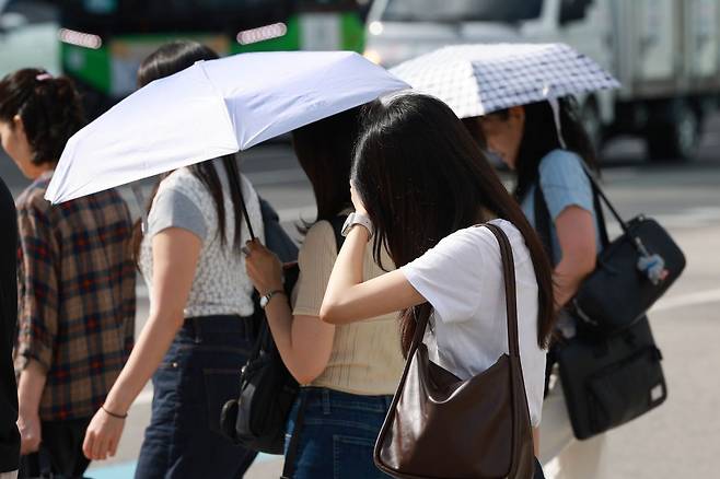 절기상 가장 더운 대서(大暑)인 22일 서울 세종대로사거리에서 시민들이 햇볕을 막으며 횡단보도를 건너고 있다. 연합뉴스
