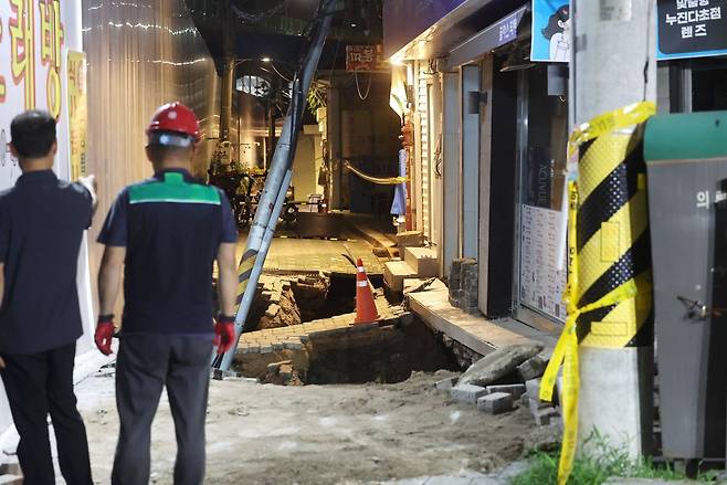 23일 서울 동대문구 이문동의 한 공사장에서 지반 침하가 발생, 관계자들이 현장을 살펴보고 있다. 연합뉴스