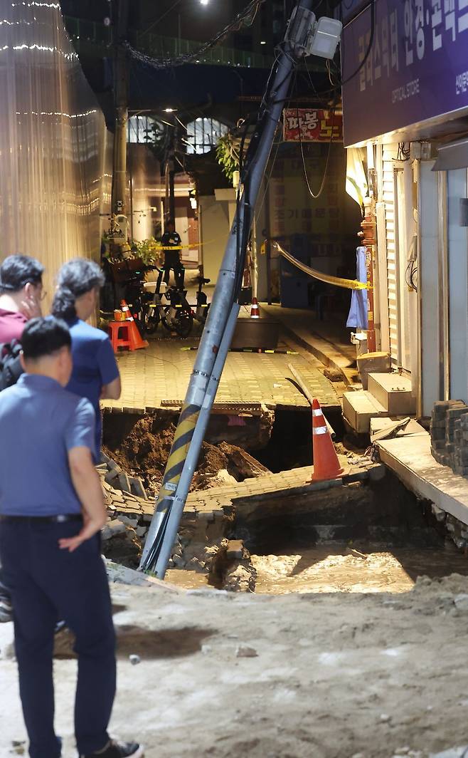 23일 서울 동대문구 이문동의 한 공사장에서 지반 침하가 발생, 관계자들이 현장을 살펴보고 있다. 연합뉴스