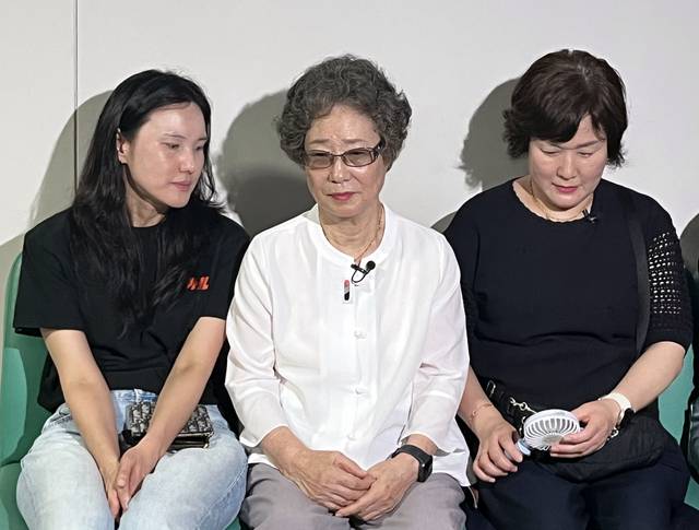 이른바 ‘강제 키스 혀 절단 사건’ 당사자인 최말자(가운데) 씨가 23일 오전 부산지법 352호 법정 앞에서 자신의 재심 첫 공판을 기다리고 있다. /연합뉴스/