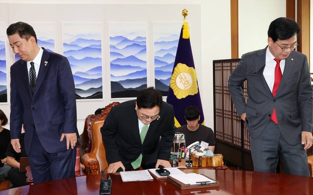 23일 오전 국회에서 우원식(가운데) 국회의장 주재로 열린 여야 원내대표 회동에서 김병기(왼쪽) 더불어민주당 대표 직무대행 겸 원내대표와 송언석(오른쪽) 국민의힘 비상대책위원장 겸 원내대표가 인사를 한 후 자리에 앉고 있다. 곽성호 기자