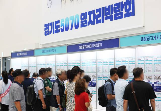 지난 9일 경기 수원시 권선구 수원메쎄에서 열린 ‘경기도 5070 일자리 박람회’에서 구직자들이 채용정보 게시판을 살펴보고 있다. 연합뉴스.