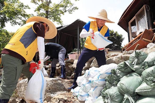 23일 충남 서산시 수해 피해 마을에서 환경정비 활동 중인 이성해(오른쪽) 국가철도공단 이사장과 본사 직원봉사단. [국가철도공단 제공]