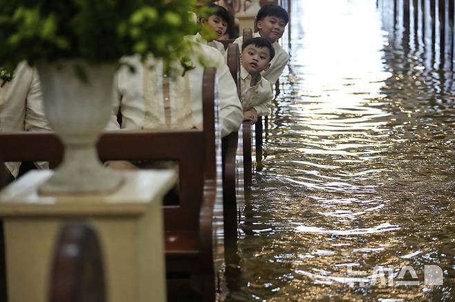 [말로로스=AP/뉴시스] 22일(현지 시간) 필리핀 불라칸 주 말로로스 바라소인 교회에서 열린 결혼식에서 하객들이 신혼부부를 바라보고 있다. 2025.07.23.
