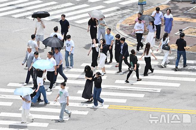 [광주=뉴시스] 이영주 기자 = 광주지역에 폭염특보가 8일째 이어지고 있는 4일 오후 광주 북구청 사거리에서 시민들이 강한 햇빛을 받으며 횡단보도 위를 걷고 있다. 2025.07.04. leeyj2578@newsis.com