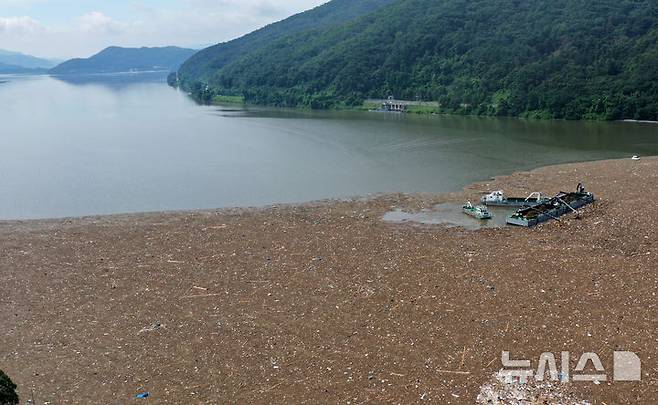 [남양주=뉴시스] 이영환 기자 = 23일 오전 경기도 남양주시 팔당댐 수면에서 관계자들이 호우로 떠내려온 쓰레기와 부유물 처리 작업을 하고 있다.  2025.07.23. 20hwan@newsis.com