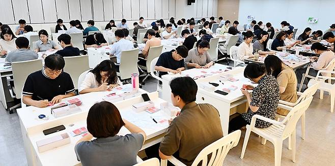 24일 광주시청에서 공무원들이 민생회복 소비쿠폰 선불카드에 스티커를 붙이는 방식으로 색상을 교체하고 있다. 당초 광주시는 소비쿠폰 선불카드 지급 금액을 구분해 3개 색상의 카드를 지급한 뒤 질타가 쏟아지자 단일 색상으로 뒤늦게 교체하고 있다./김애리 기자