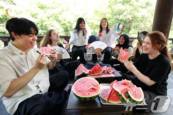 24일 오후 대구 달서구 계명대 성서캠퍼스 한학촌에서 열린 '외국인 유학생 여름나기' 행사에 참여한 학생들이 시원한 수박을 나눠 먹으며 한국 유학 생활에 대한 소감을 털어놓고 있다. 2025.7.24/뉴스1 ⓒ News1 공정식 기자