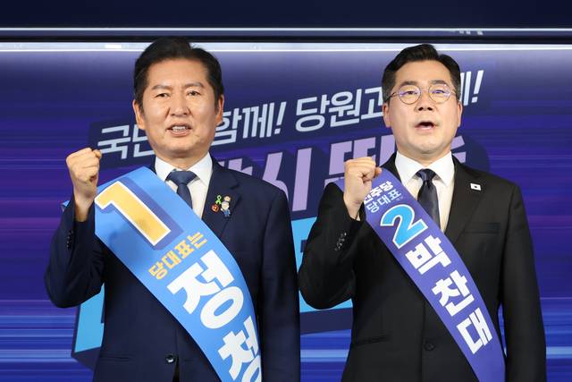 더불어민주당 대표 선거에 출마한 정청래(왼쪽)·박찬대 의원이 지난 20일 서울 여의도 당사에서 열린 8·2 전당대회 순회 경선 영남권 합동연설회에서 파이팅을 외치며 기념촬영 하고 있다. [연합뉴스]