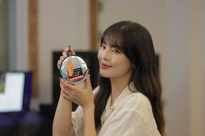 배우 이선빈이 ‘국민히어로즈’ 캠페인 리워드인 업사이클링 파우치와 넘버링 키링을 들고 사진촬영을 하고 있다. 희망브리지 제공