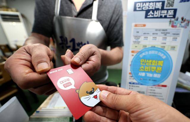 22일 대구 중구 한 음식점에서 식사를 마친 시민이 소비쿠폰이 입금된 선불카드로 결제하고 있다. 뉴시스