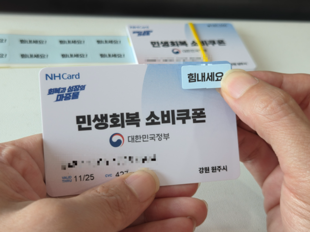 ▲ 24일 원주시청 공무원이 시민들에게 배급될 민생회복 소비쿠폰에 ‘힘내세요’ 라는 문구가 적힌 스티커를 부착하고 있다.