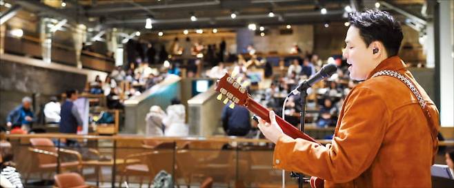 ‘별빛 라이브’ 공연이 열리는 서울 제기동 스타벅스 경동1960점에서 한 연주자가 기타를 치며 노래를 부르고 있다. 스타벅스 제공