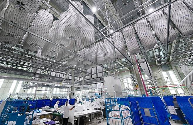 세탁이 완료된 세탁물이 백 시스템(bag system)을 통해 천장 라인을 따라 대기 후 작업 구역으로 자동 이송되고 있다. 안성=은정진 기자